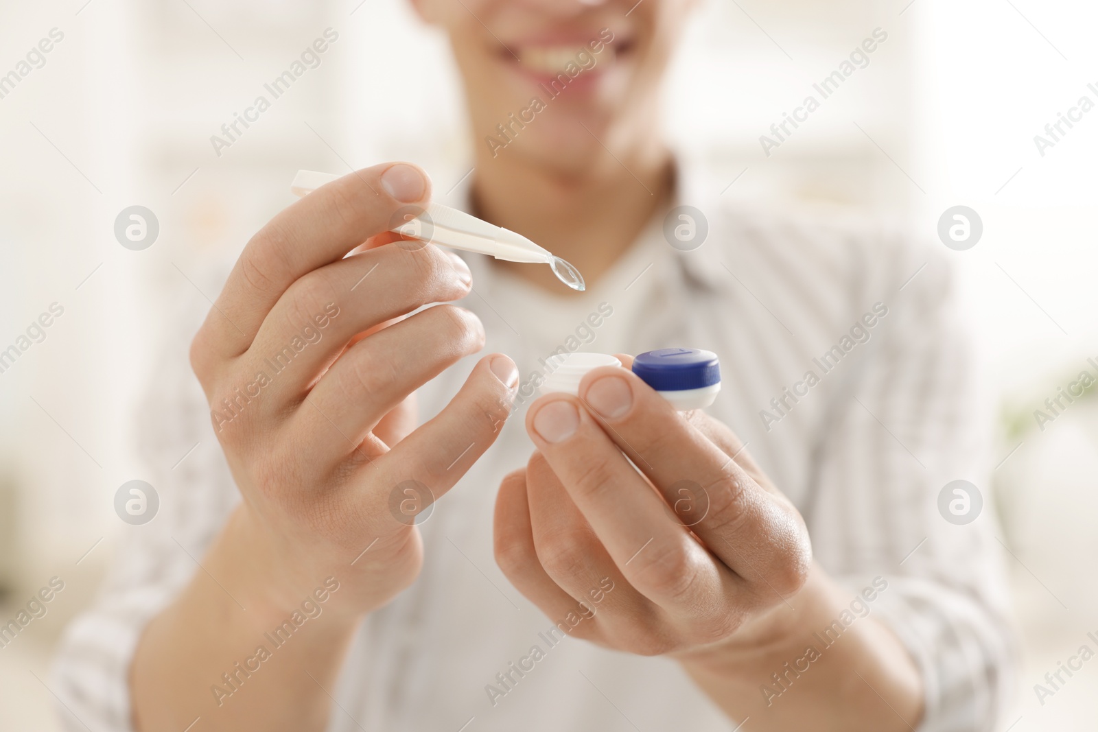Man taking contact lens out of case at home, closeup Photo of Man taking contact lens out of case at home, closeup