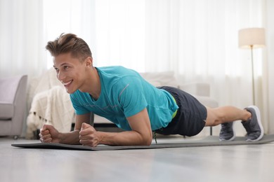 Photo of Man doing plank exercise at home. Sport and healthy lifestyle