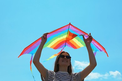 Photo of Woman with colorful kite under blue sky, low angle view