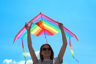 Photo of Woman with colorful kite under blue sky, low angle view