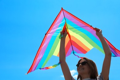 Photo of Woman with colorful kite under blue sky, low angle view