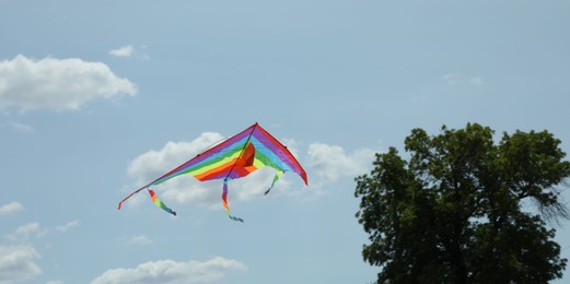 Photo of Colorful kite flying in blue sky, low angle view