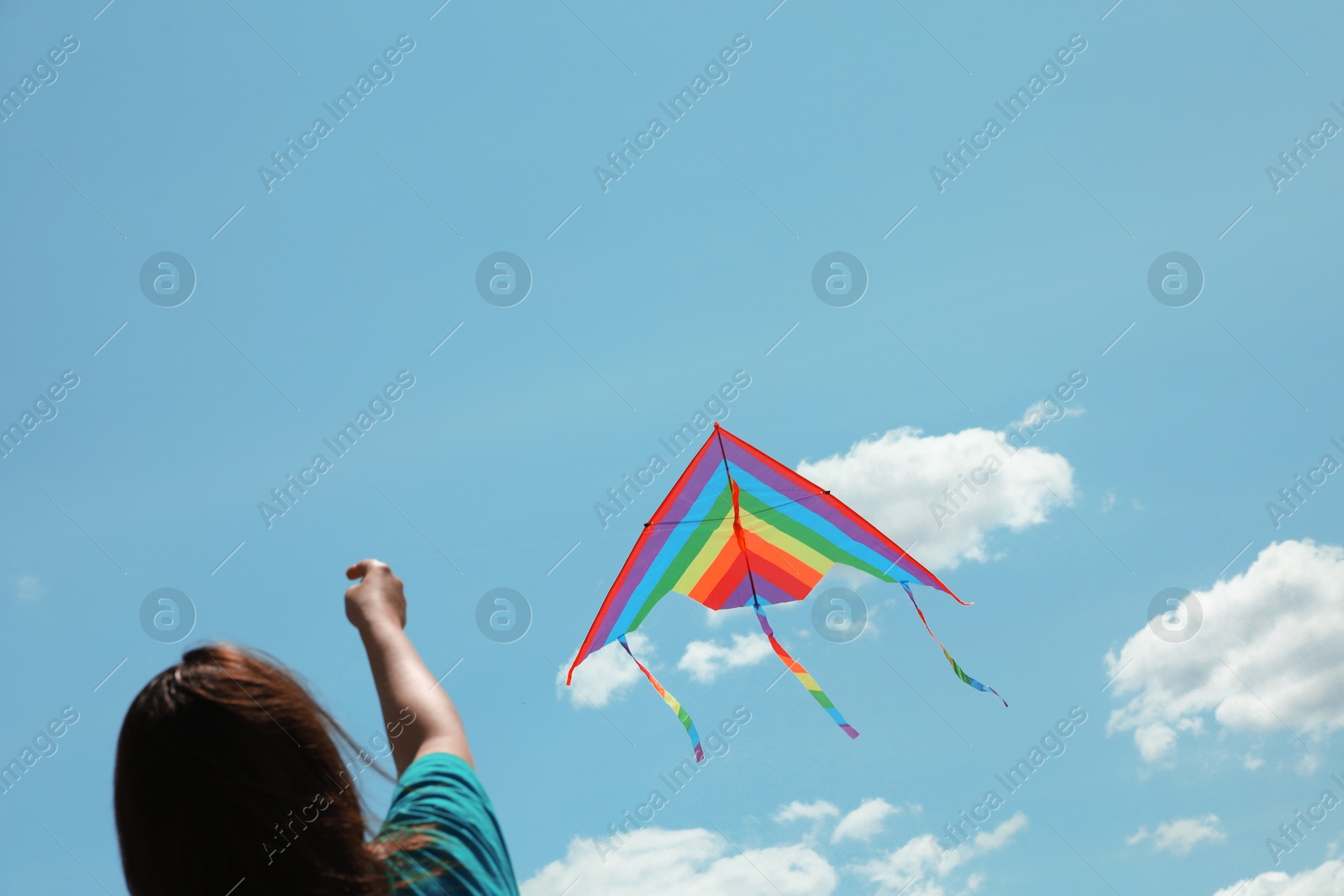 Woman with colorful kite under blue sky, low angle view Photo of Woman with colorful kite under blue sky, low angle view