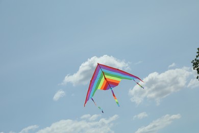 Photo of Colorful kite flying in blue sky, low angle view. Space for text