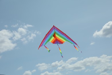 Photo of Colorful kite flying in blue sky, low angle view