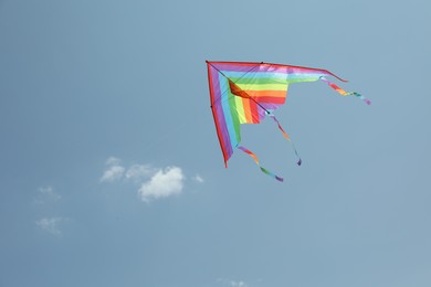 Photo of Colorful kite flying in blue sky, low angle view. Space for text