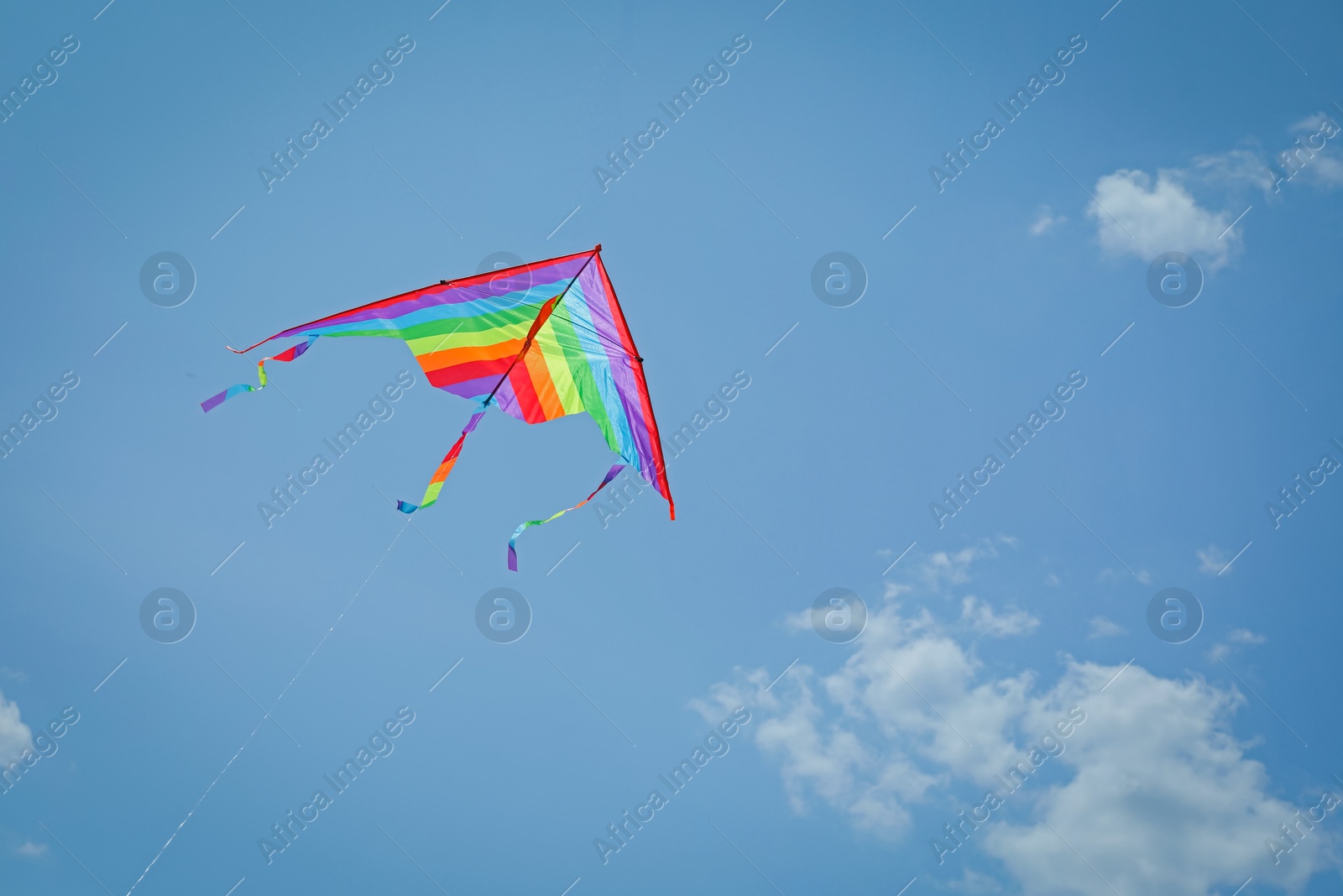Colorful kite flying in blue sky, low angle view. Space for text Photo of Colorful kite flying in blue sky, low angle view. Space for text