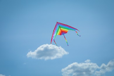 Photo of Colorful kite flying in blue sky, low angle view. Space for text
