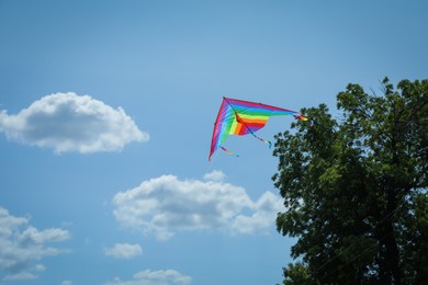 Photo of Colorful kite flying in blue sky, low angle view. Space for text