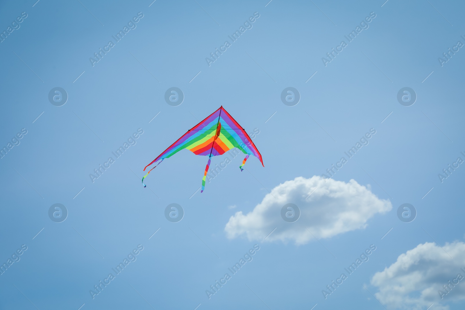 Colorful kite flying in blue sky, low angle view Photo of Colorful kite flying in blue sky, low angle view