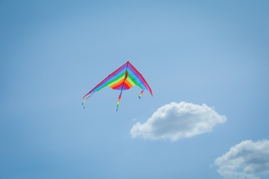 Photo of Colorful kite flying in blue sky, low angle view