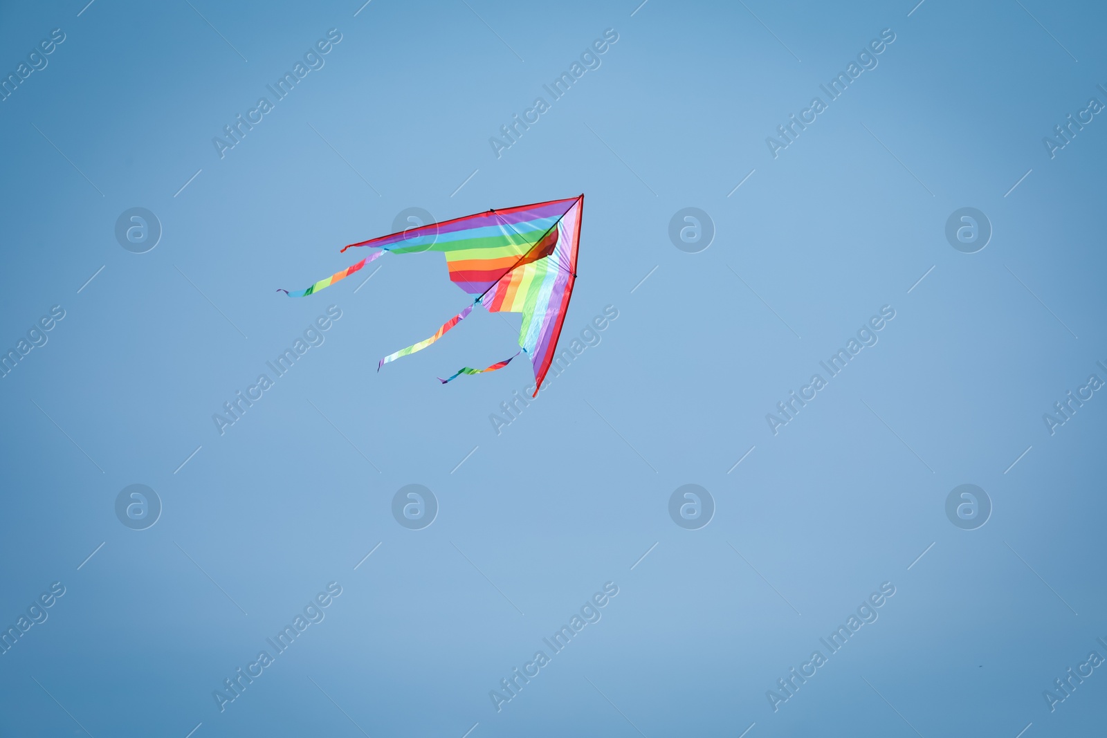Colorful kite flying in blue sky, low angle view. Space for text Photo of Colorful kite flying in blue sky, low angle view. Space for text