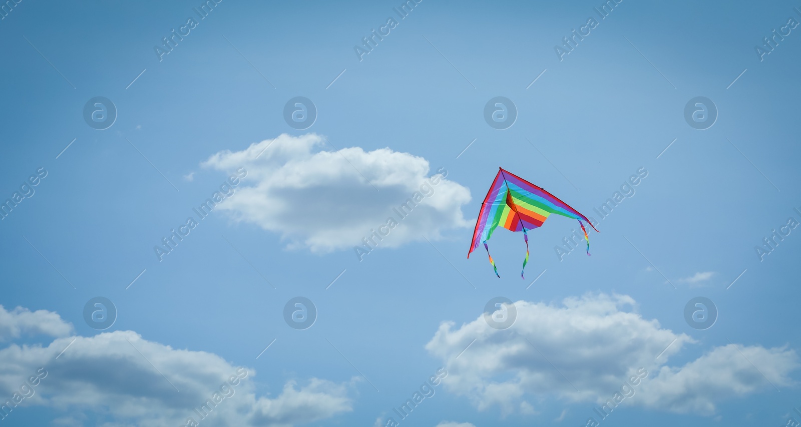 Colorful kite flying in blue sky, low angle view. Space for text Photo of Colorful kite flying in blue sky, low angle view. Space for text