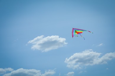 Photo of Colorful kite flying in blue sky, low angle view. Space for text