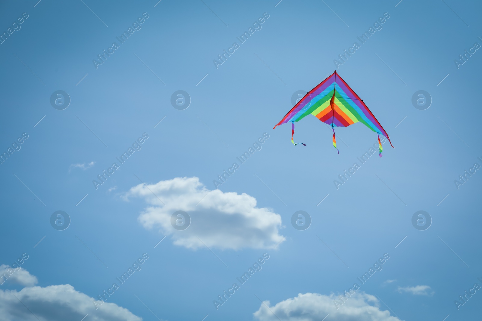 Colorful kite flying in blue sky, low angle view. Space for text Photo of Colorful kite flying in blue sky, low angle view. Space for text
