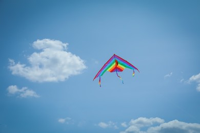 Photo of Colorful kite flying in blue sky, low angle view. Space for text