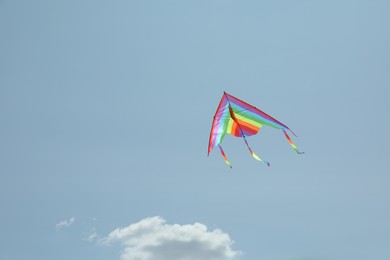 Photo of Colorful kite flying in blue sky, low angle view. Space for text