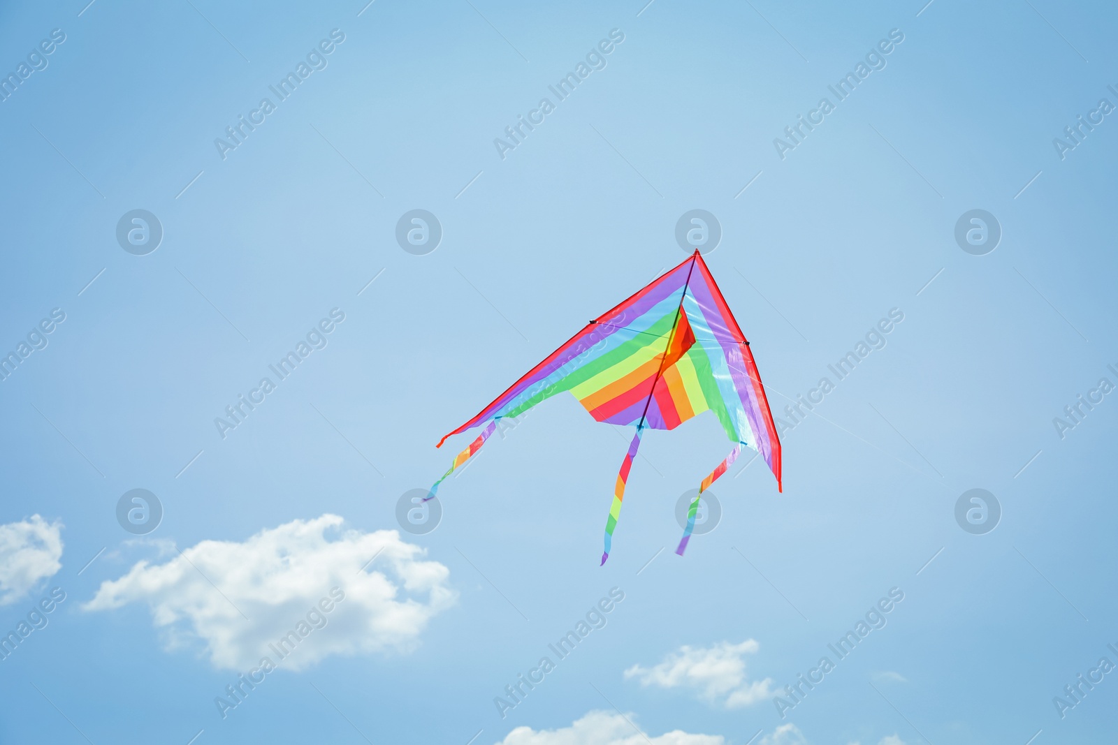 Colorful kite flying in blue sky, low angle view Photo of Colorful kite flying in blue sky, low angle view