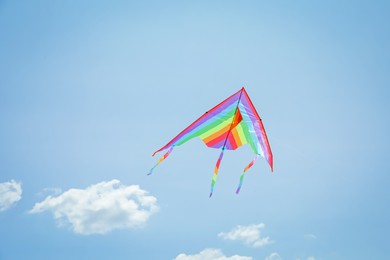 Photo of Colorful kite flying in blue sky, low angle view