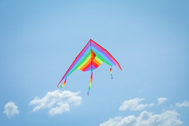 Photo of Colorful kite flying in blue sky, low angle view