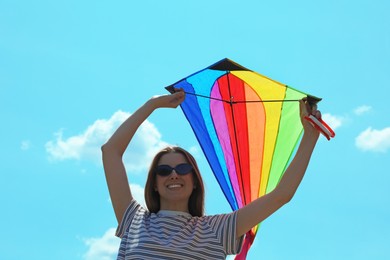 Photo of Woman with colorful kite under blue sky, low angle view
