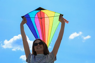 Photo of Woman with colorful kite under blue sky, low angle view