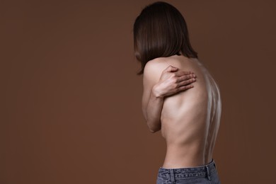 Photo of Woman suffering from anorexia on brown background, space for text