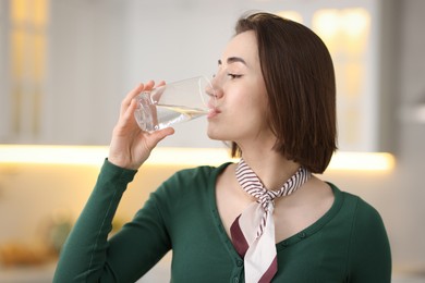 Photo of Young woman drinking water from at home