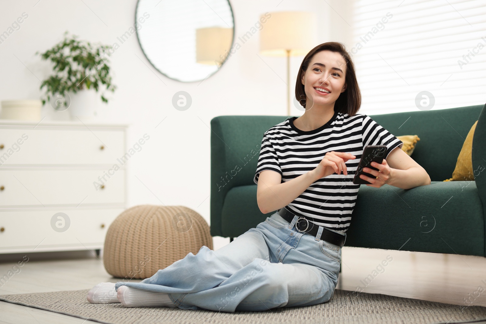 Woman using modern smartphone on floor at home. Space for text Photo of Woman using modern smartphone on floor at home. Space for text