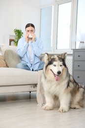 Photo of Woman suffering from allergy with her dog at home