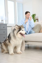 Photo of Woman suffering from allergy with her dog at home