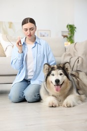 Photo of Woman suffering from allergy with her dog at home