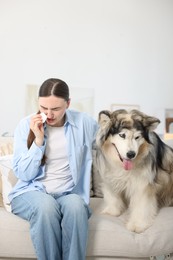 Photo of Woman suffering from allergy with her dog at home