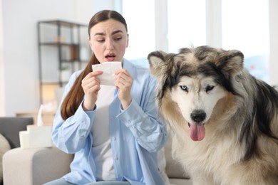 Photo of Woman suffering from allergy with her dog at home