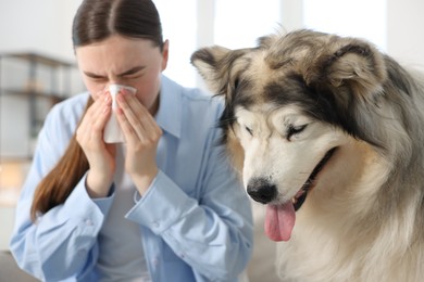 Photo of Woman suffering from allergy with her dog at home