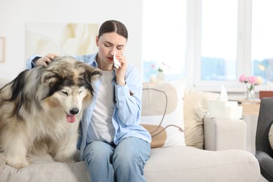 Photo of Woman suffering from allergy with her dog at home