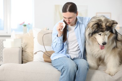 Photo of Woman suffering from allergy with her dog at home