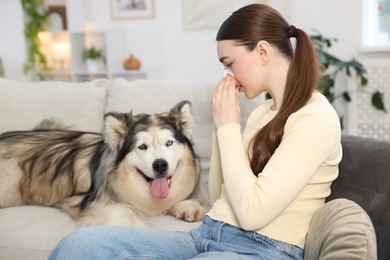 Photo of Woman suffering from allergy with her dog at home