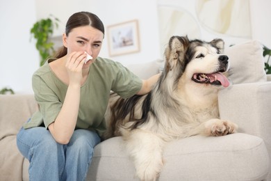 Photo of Woman suffering from allergy with her dog at home