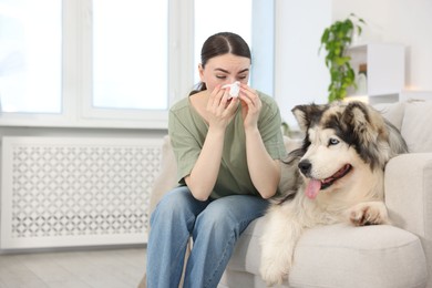 Photo of Woman suffering from allergy with her dog at home. Space for text
