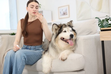 Photo of Woman suffering from allergy with her dog at home