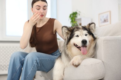 Photo of Woman suffering from allergy with her dog at home