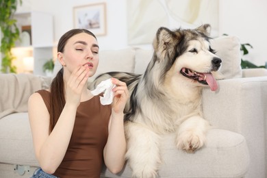 Photo of Woman suffering from allergy with her dog at home
