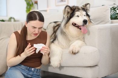 Photo of Woman suffering from allergy with her dog at home