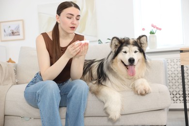 Photo of Woman suffering from allergy with her dog at home