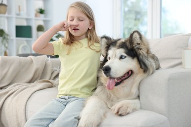 Photo of Girl suffering from allergy with her dog at home