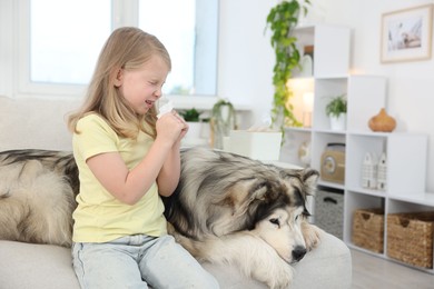 Photo of Girl suffering from allergy with her dog at home
