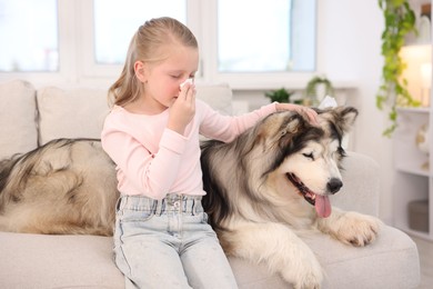 Photo of Girl suffering from allergy with her dog at home