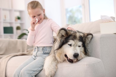 Photo of Girl suffering from allergy with her dog at home