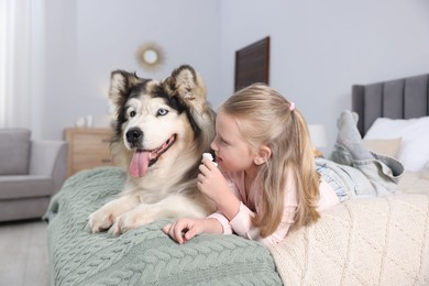 Photo of Girl suffering from allergy with her dog on bed at home
